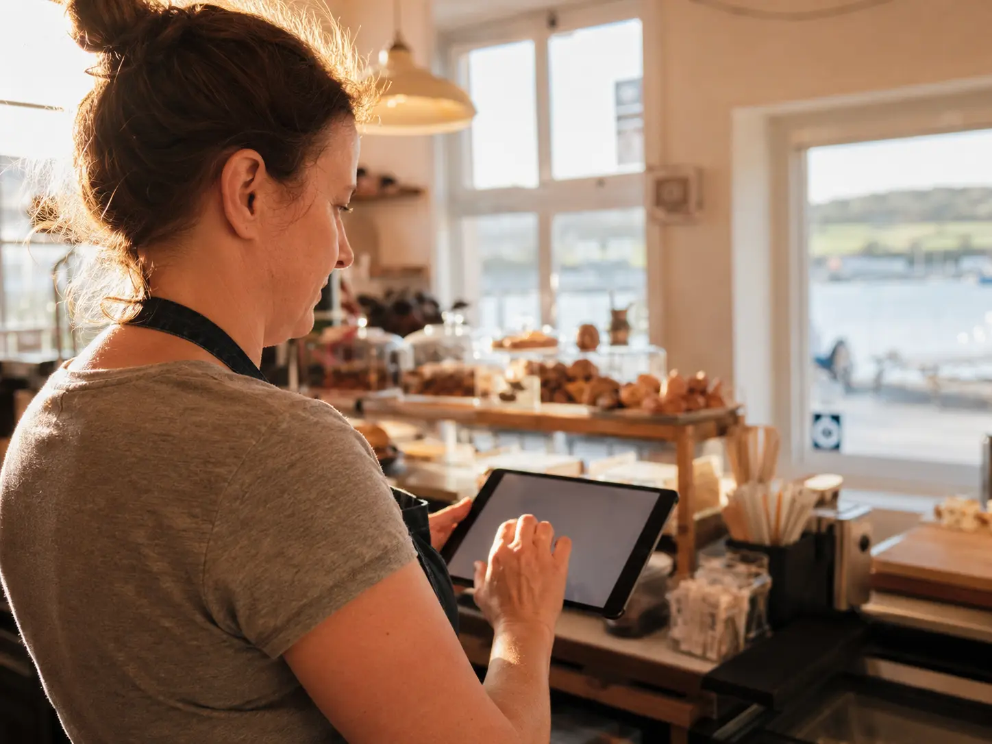Irish café owner updating their own website on a tablet behind the counter