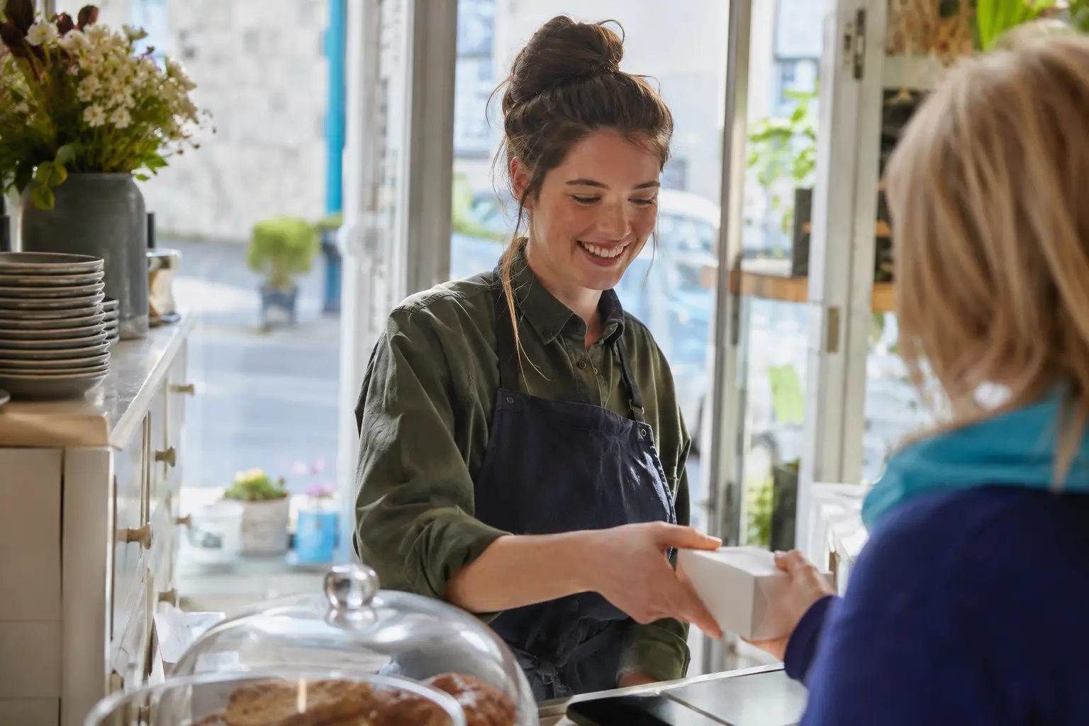 An Irish small-business owner taking an enquiry at the counter